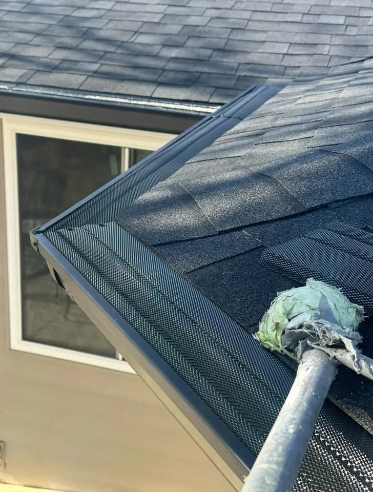 Gutter guard being fitted at an outside corner of a dark gutter