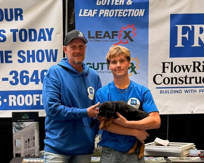 Luke and Jaxx of Flow Right Construction with Larry the shop dog in Jaxx's arms