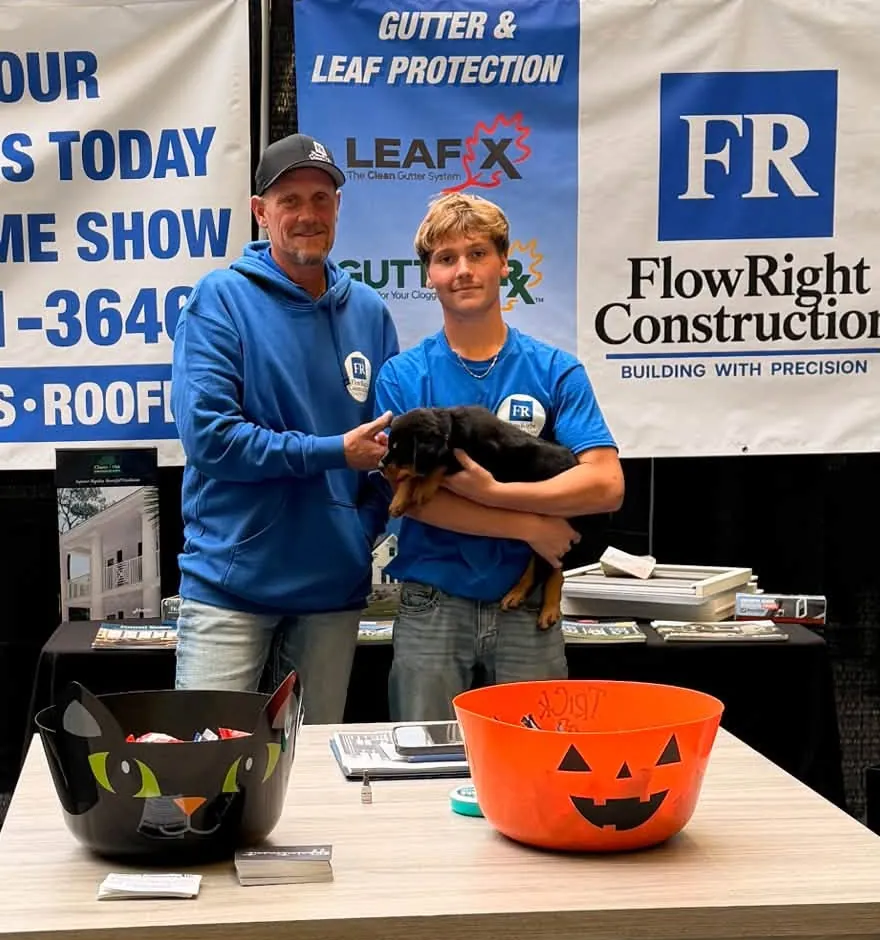 Luke and Jaxx of Flow Right Construction holding Larry, the shop dog, at their Iowa Home Expo booth