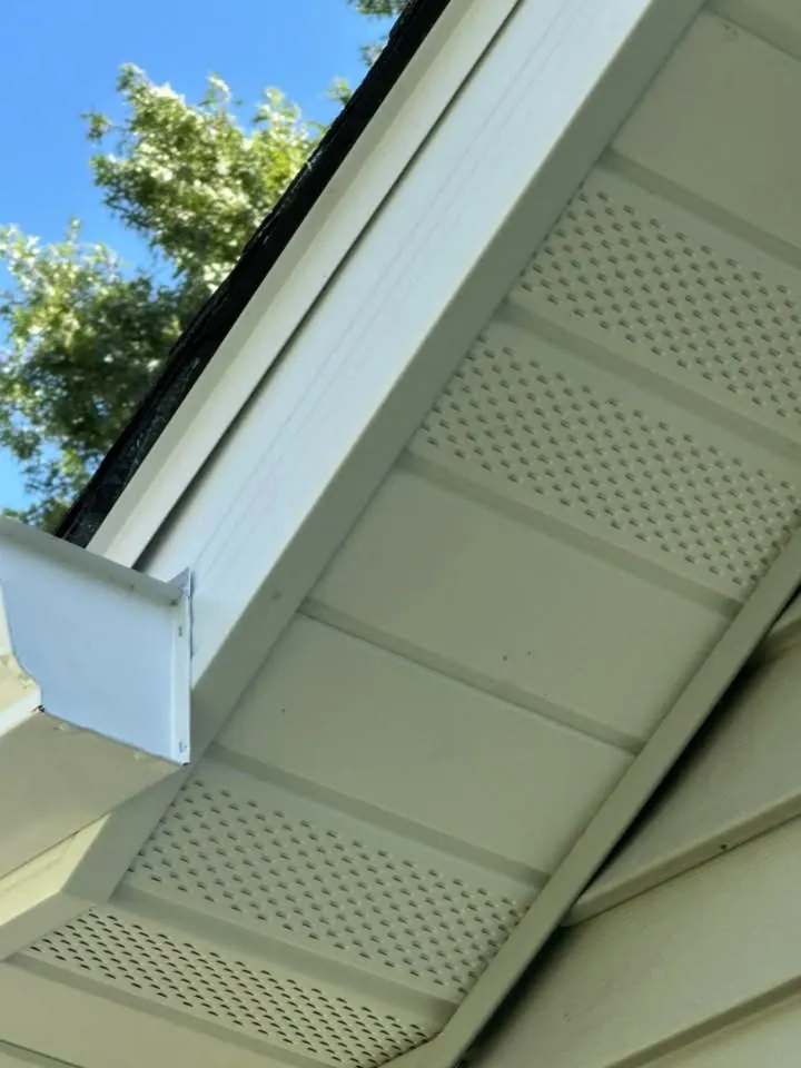 Close view of white vented soffit panels and fascia at a roof corner