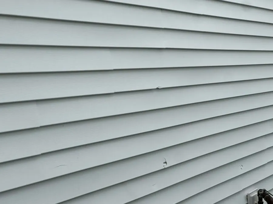 Close view of straight gray vinyl siding laps