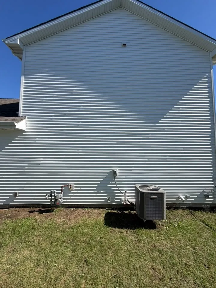White vinyl siding on a gable end above an air conditioner unit